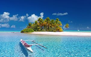 Polinezja Francuska - piaszczysta wyspa wraz z palmami i inna roślinnością otoczona lazurowym czystym morzem. Na wodzie jasna łódka. Źródło: Julius Silver (Pixabay)